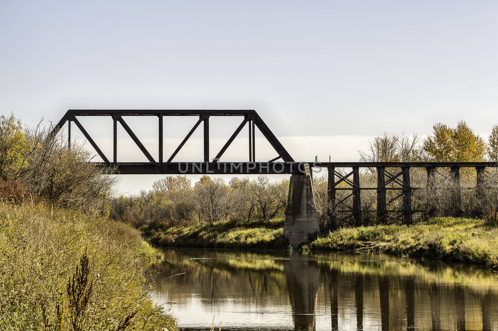 A rail bridge that crosses the narrow Battle River of Saskatchewan