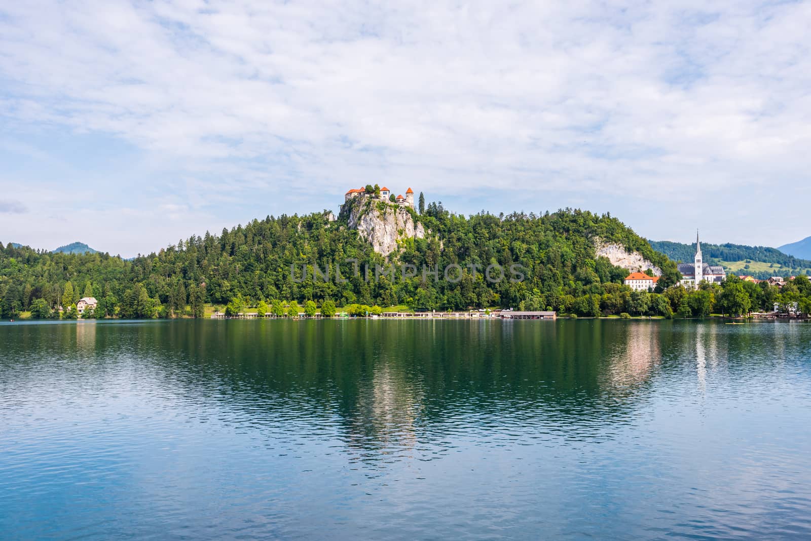 Bled Castle on a Rock at Bled Lake in Slovenia Reflected on Water Surface with Cloudy Sky