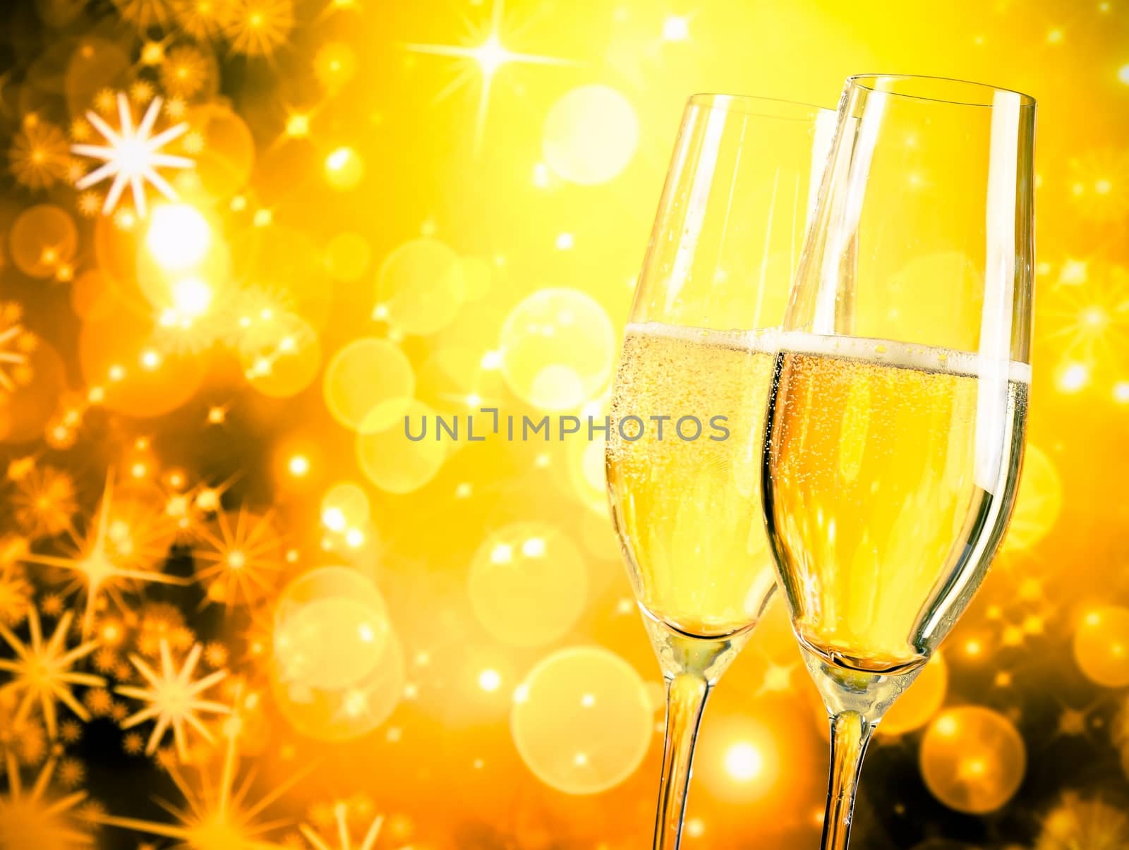 a pair of champagne flutes with golden bubbles on golden light background with space for text