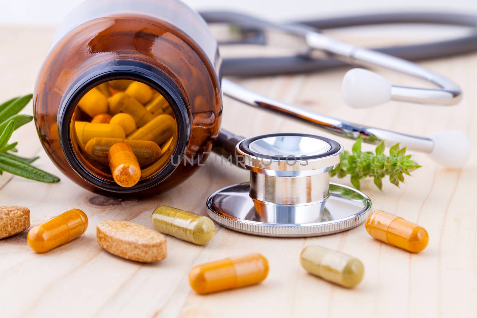 capsule of herbal medicine alternative healthy care with stethoscope wooden background.