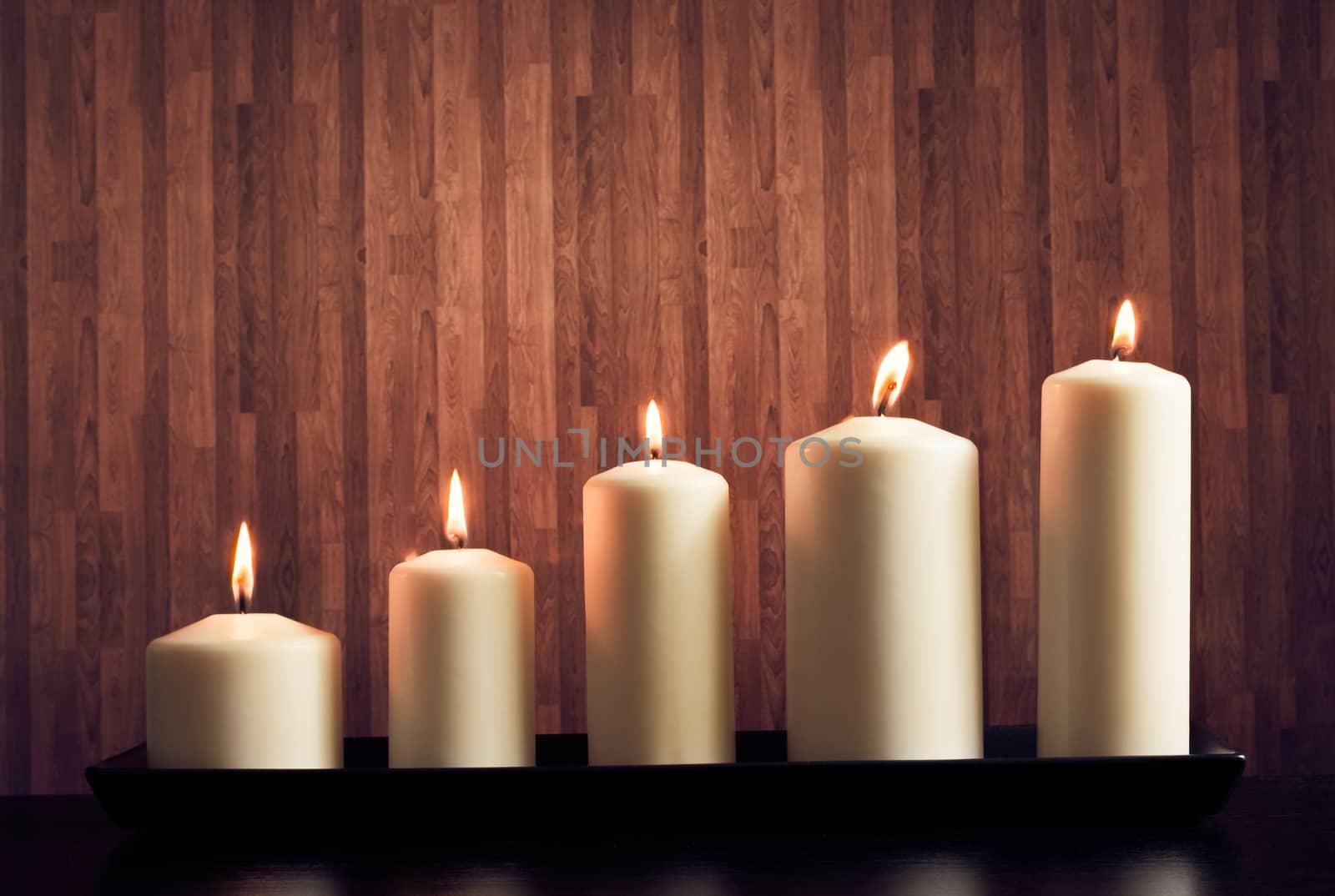 white candles on warm atmosphere and old wooden background