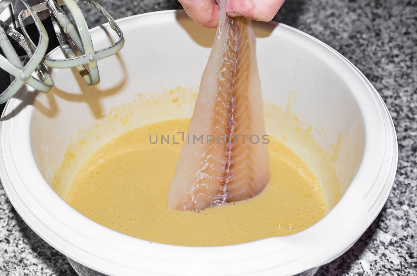 Fresh coley fillet is laid in beer batter.