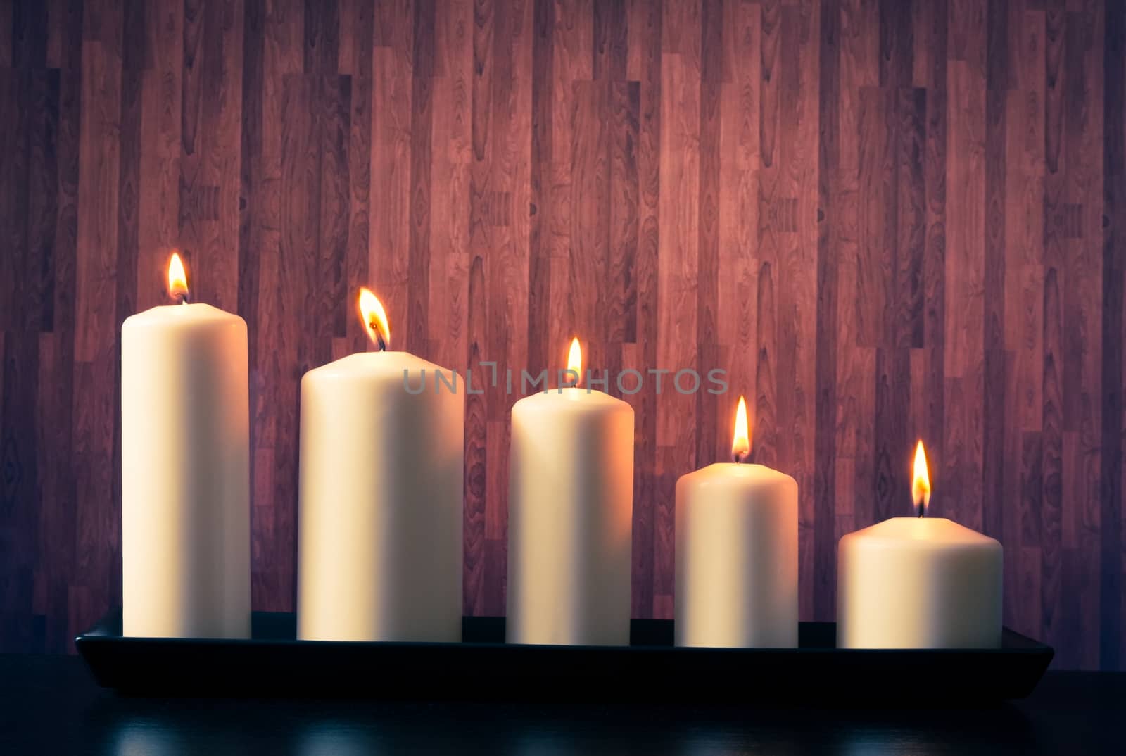 white candles on warm atmosphere and old wooden background