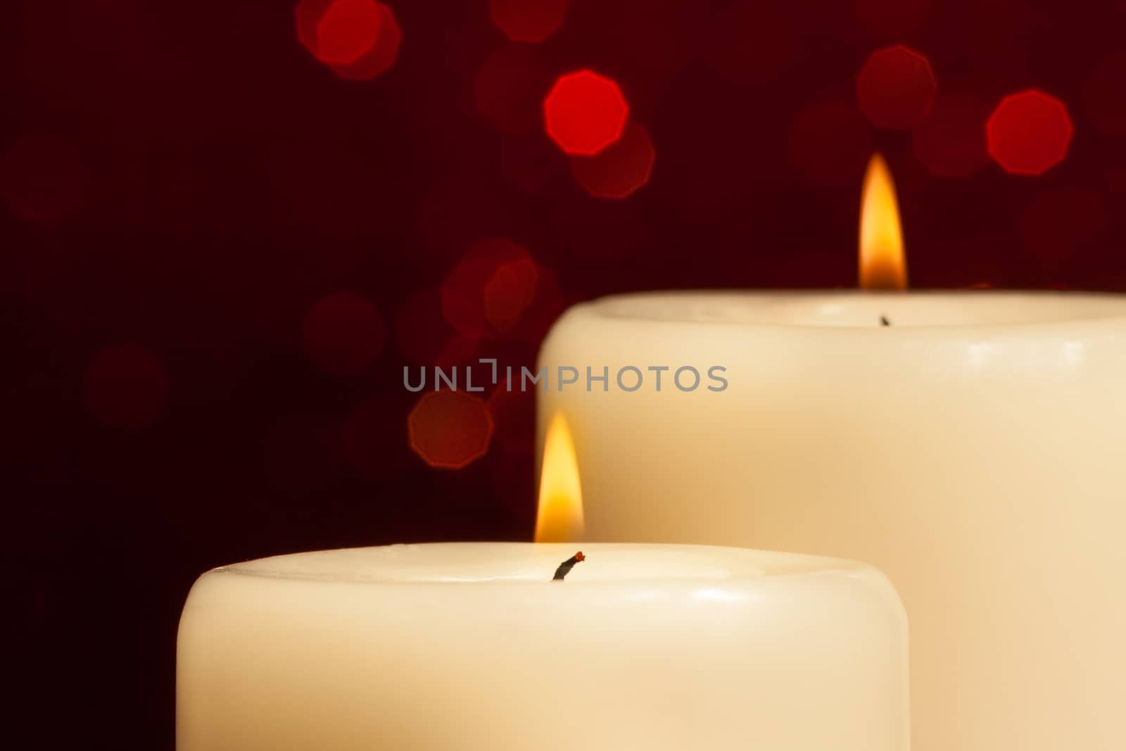close-up of candles with flame on red bokeh by donfiore