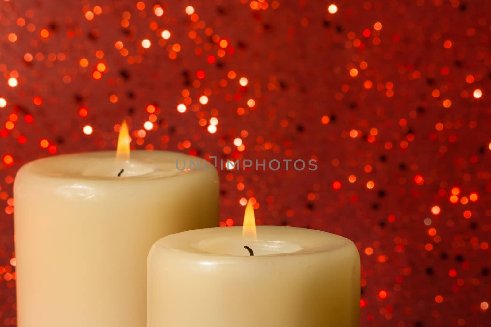 candles with flame on red bokeh background and space for text