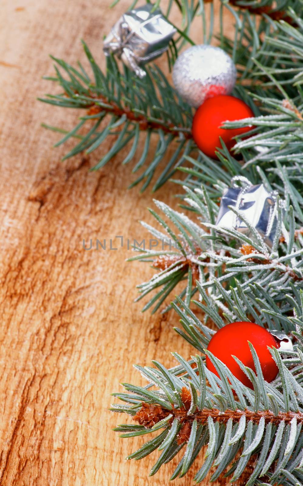 Christmas Decoration with Spruce Branch with Hoarfrost, Small Red Bauble and Silver Gift Box closeup on Textured Wooden background
