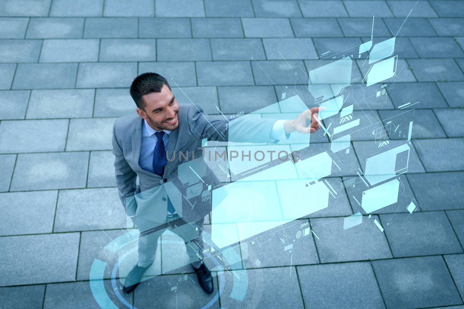 business, development, technology and people and concept - young smiling businessman pointing finger to virtual screens outdoors from top