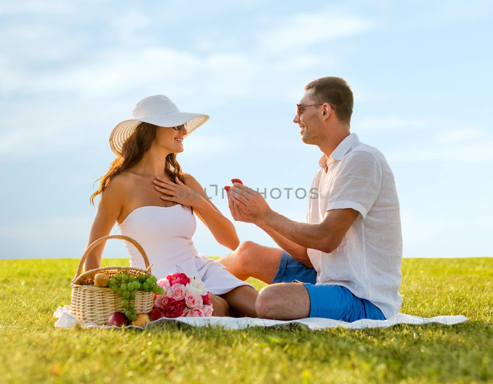 smiling couple with small red gift box on picnic by dolgachov