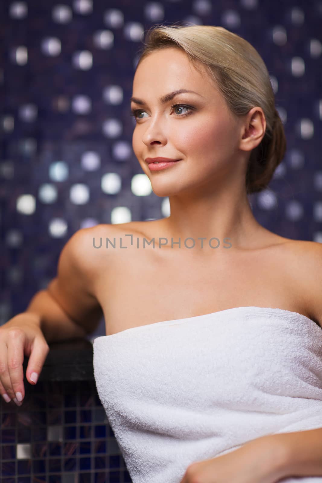 people, beauty, spa, healthy lifestyle and relaxation concept - beautiful young woman sitting in bath towel