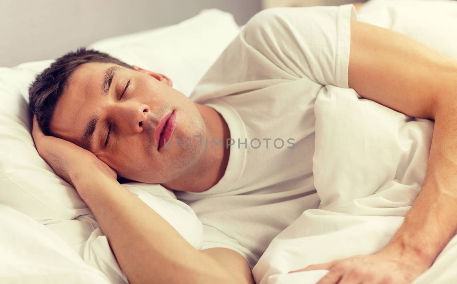 handsome man sleeping in bed by dolgachov