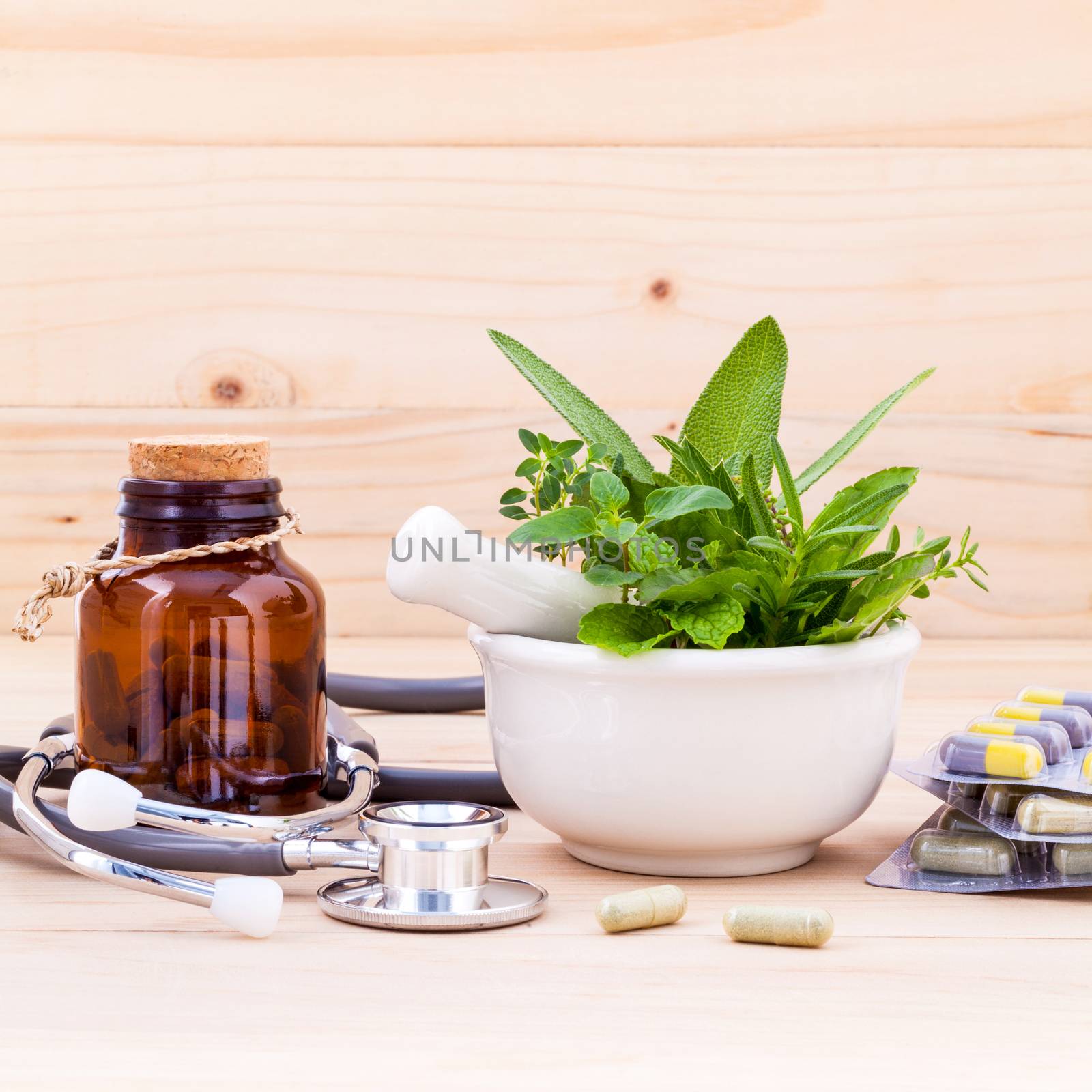 Capsule of herbal medicine alternative healthy care with stethoscope on wooden background.