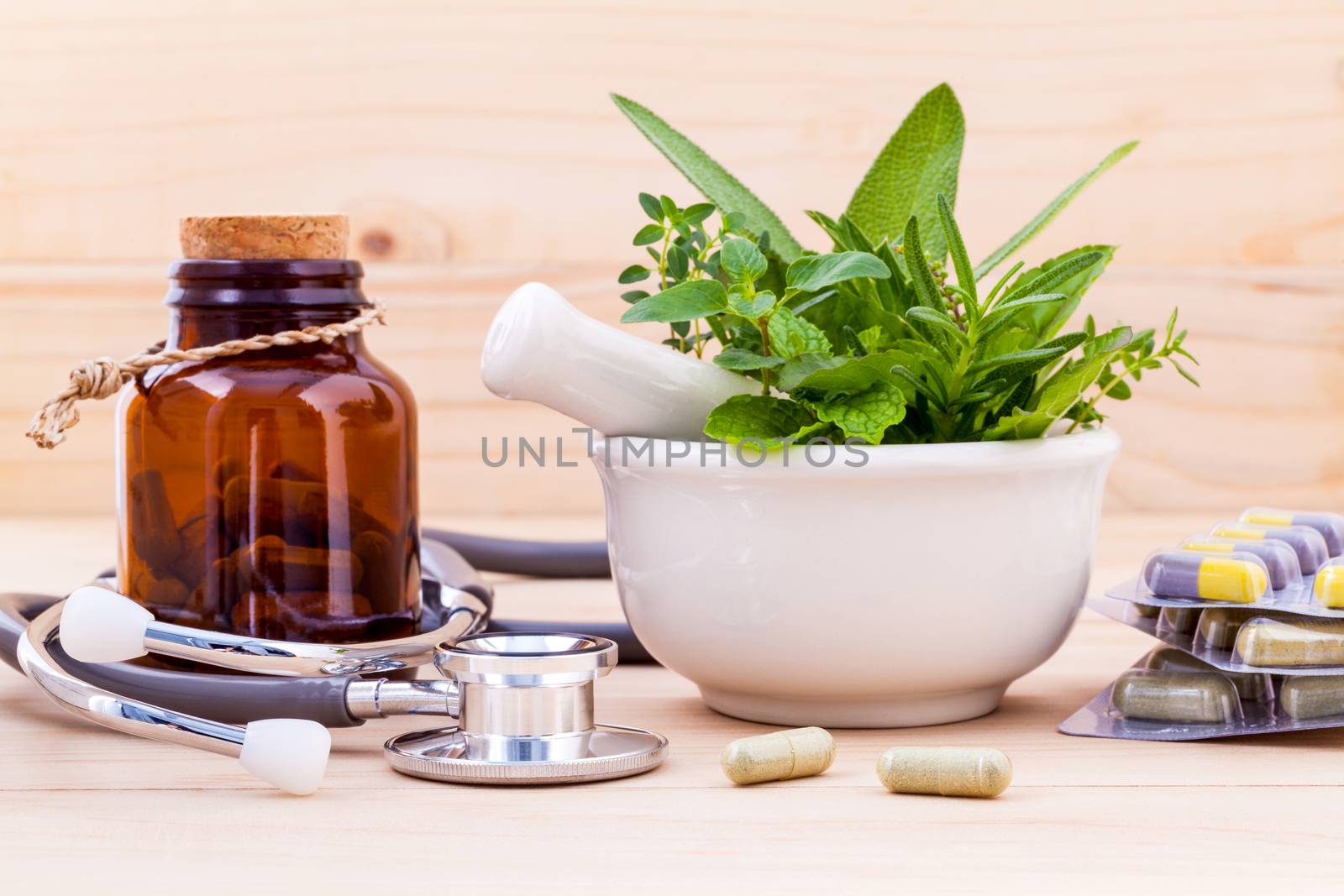 Capsule of herbal medicine alternative healthy care with stethoscope on wooden background.