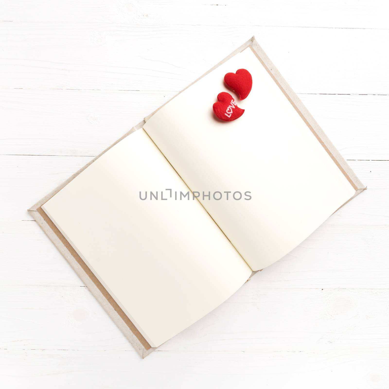 heart on notebook over white table