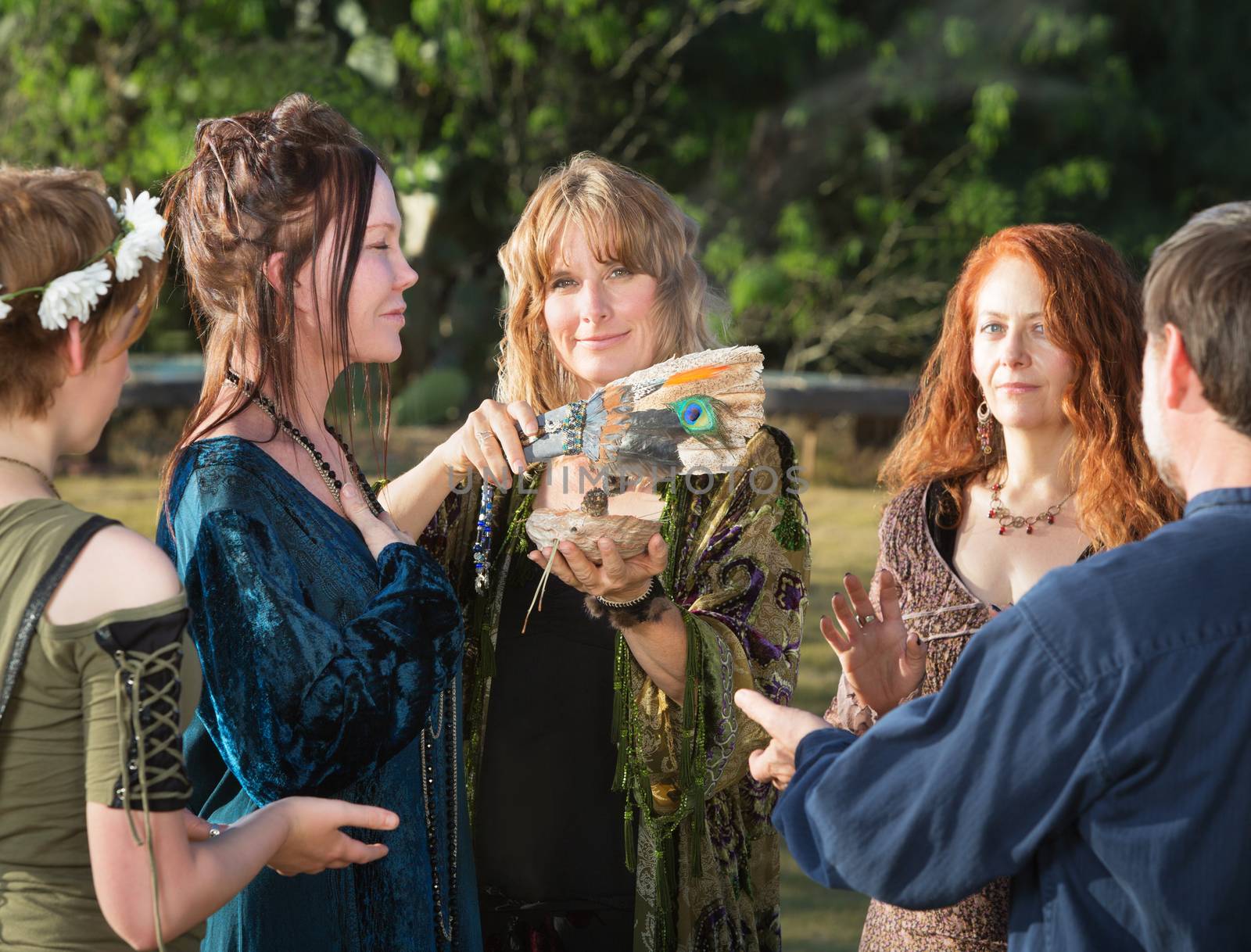 Group of Wicca men and women using feather and incense