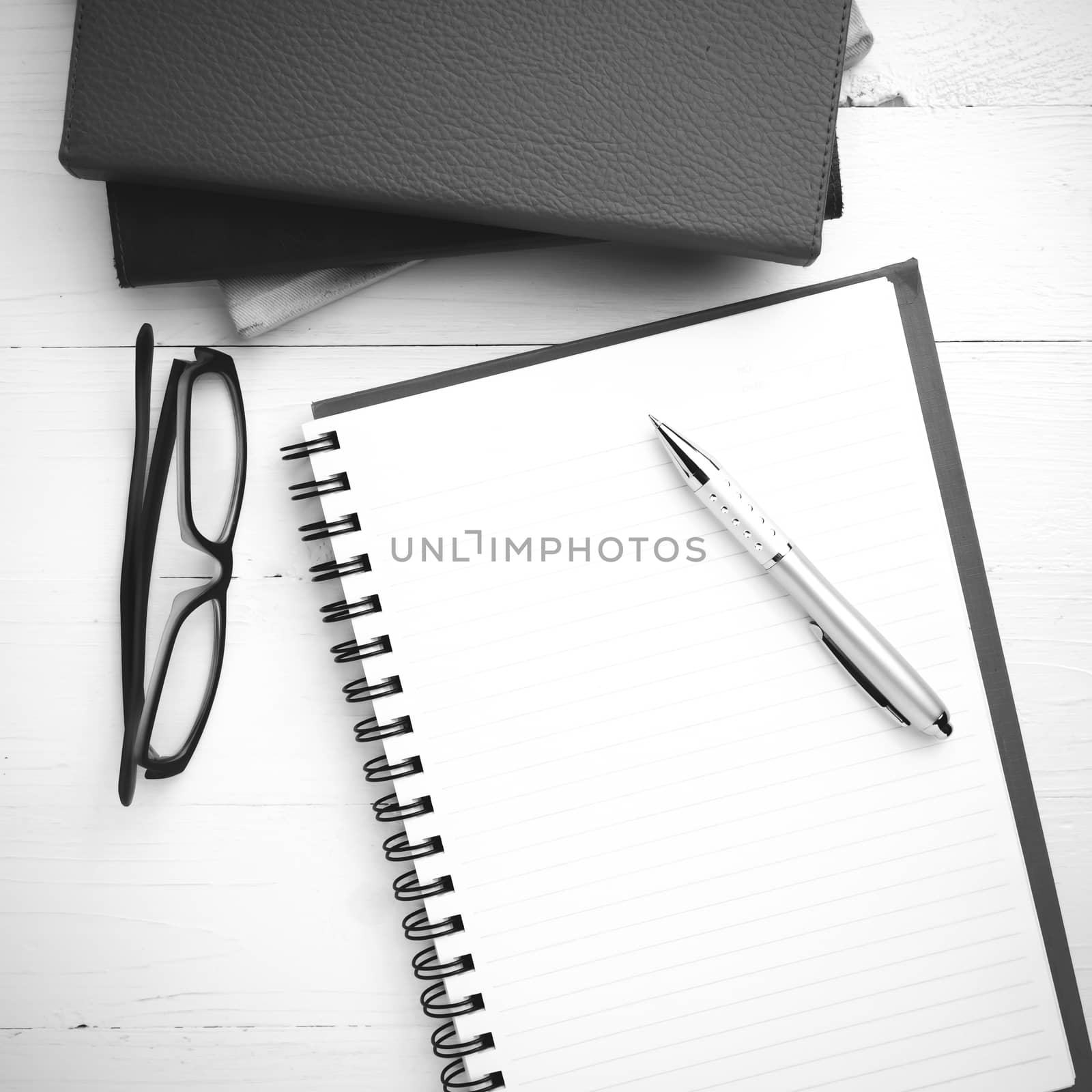 notepad with stack of book on table view from above black and white tone color style