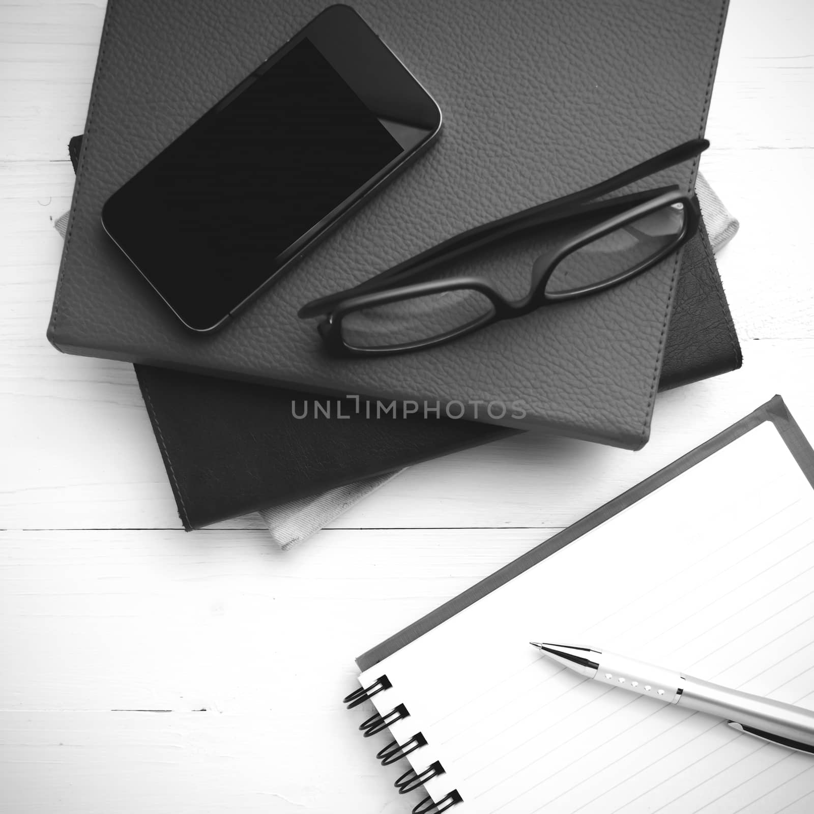 notepad with stack of book on table view from above black and white tone color style