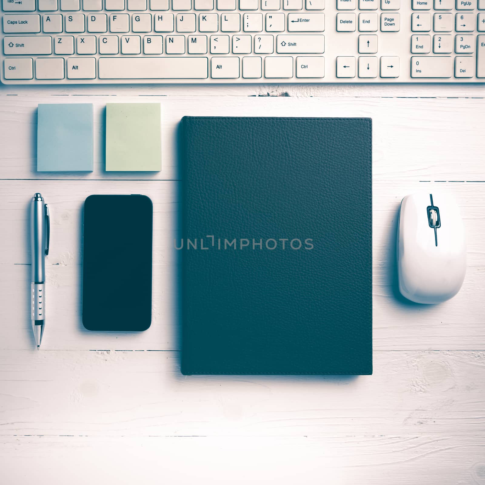 computer and brown notebook with office supplies on white table vintage style