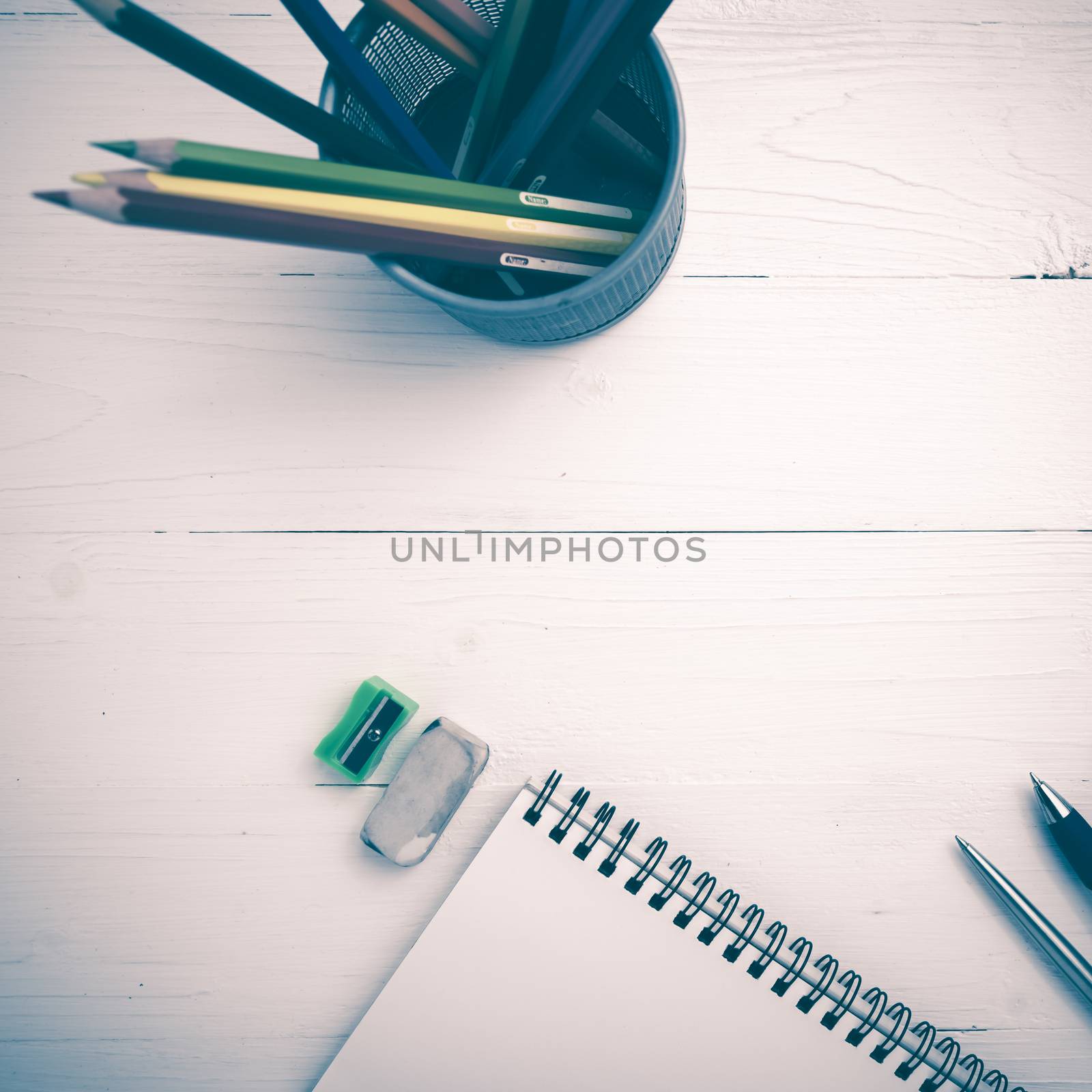notepad with color pencil on white table view from above vintage style