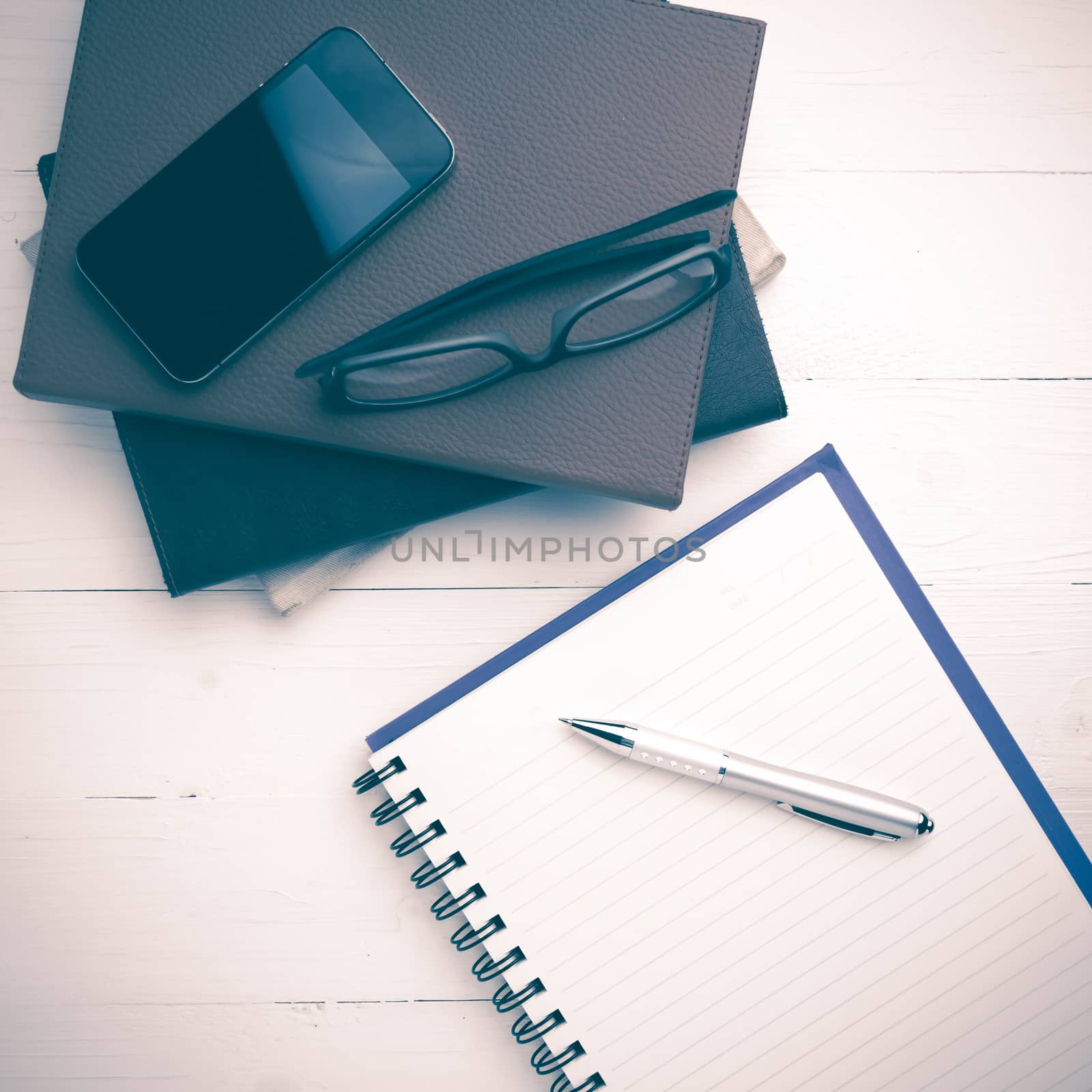 notepad with stack of book on white table view from above vintage style