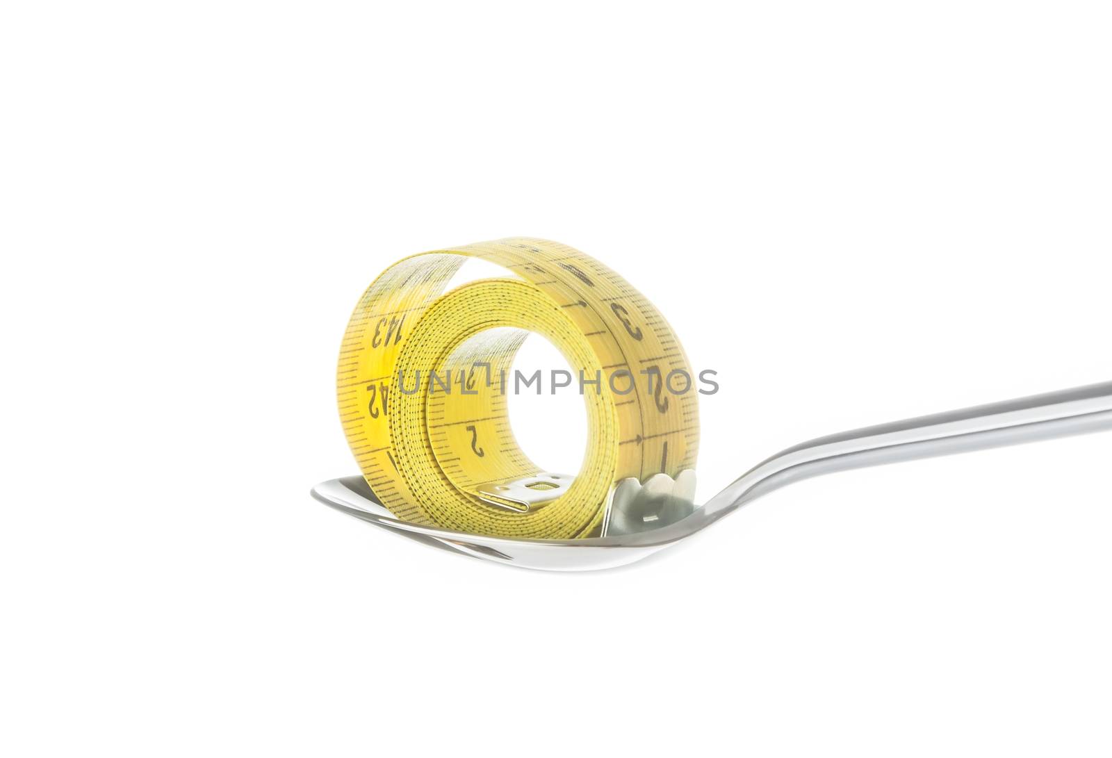 measuring tape on spoon, concept of nutrition and diet on white background