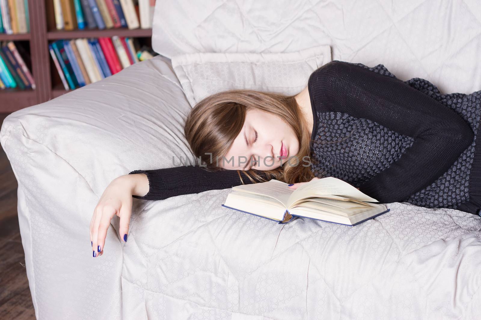 Cute girl sleeping while holding a book lying by victosha