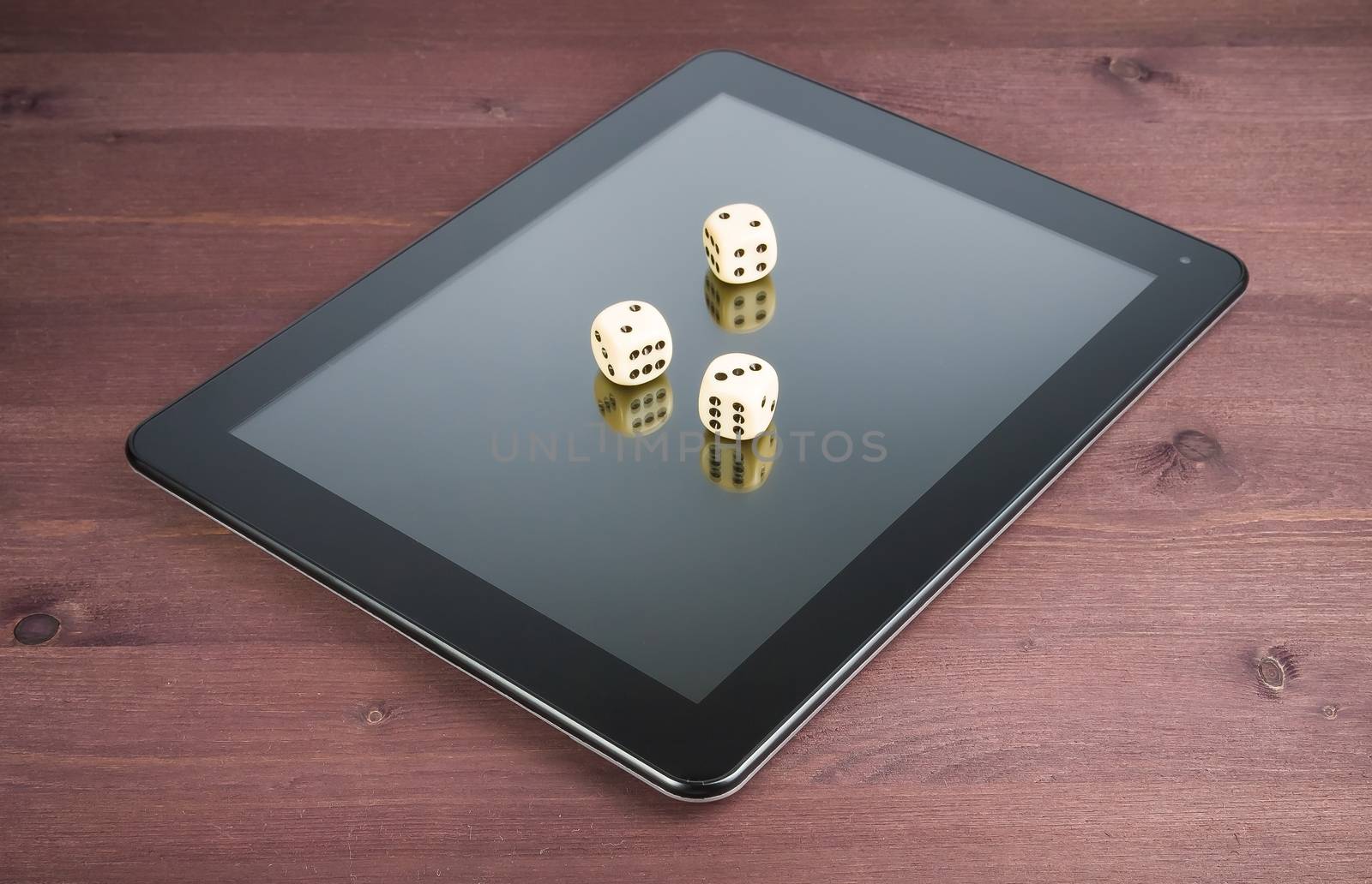 three dice on digital tablet pc on old wood table, concept of texas game online