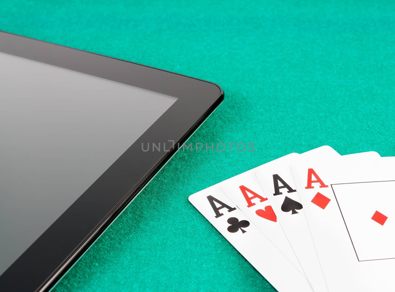 poker cards near digital tablet pc concept of poker online by donfiore
