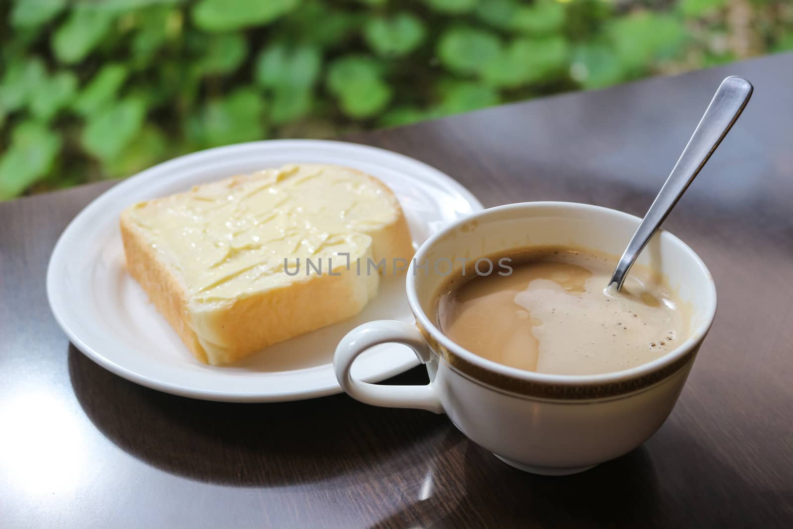 cup of coffee toast with butter on wooden table