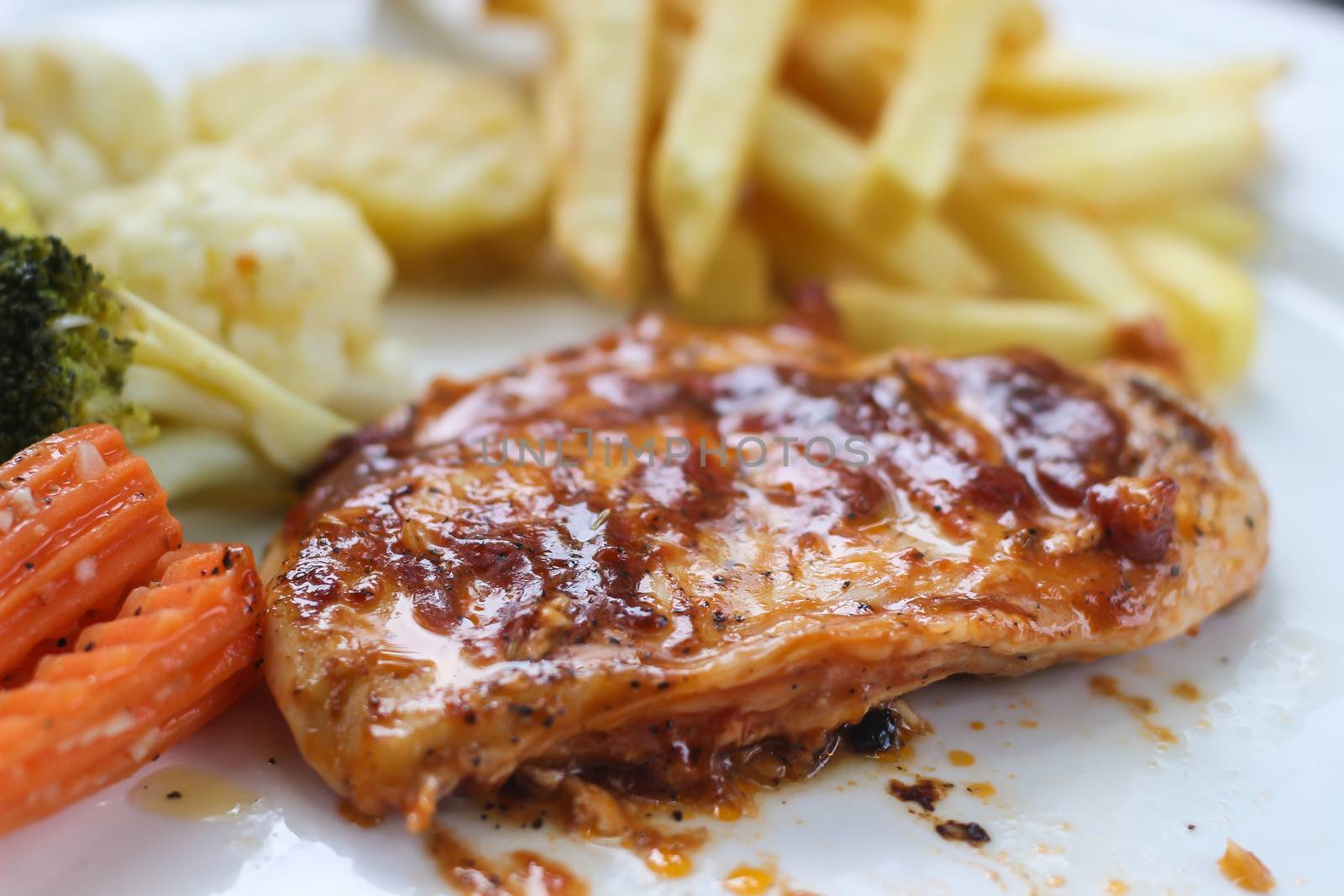 Chicken steak served with french fries and salads to vegetables