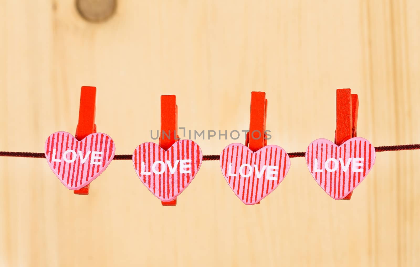 four decorative hearts hanging on wood background, concept of valentine day in love by donfiore