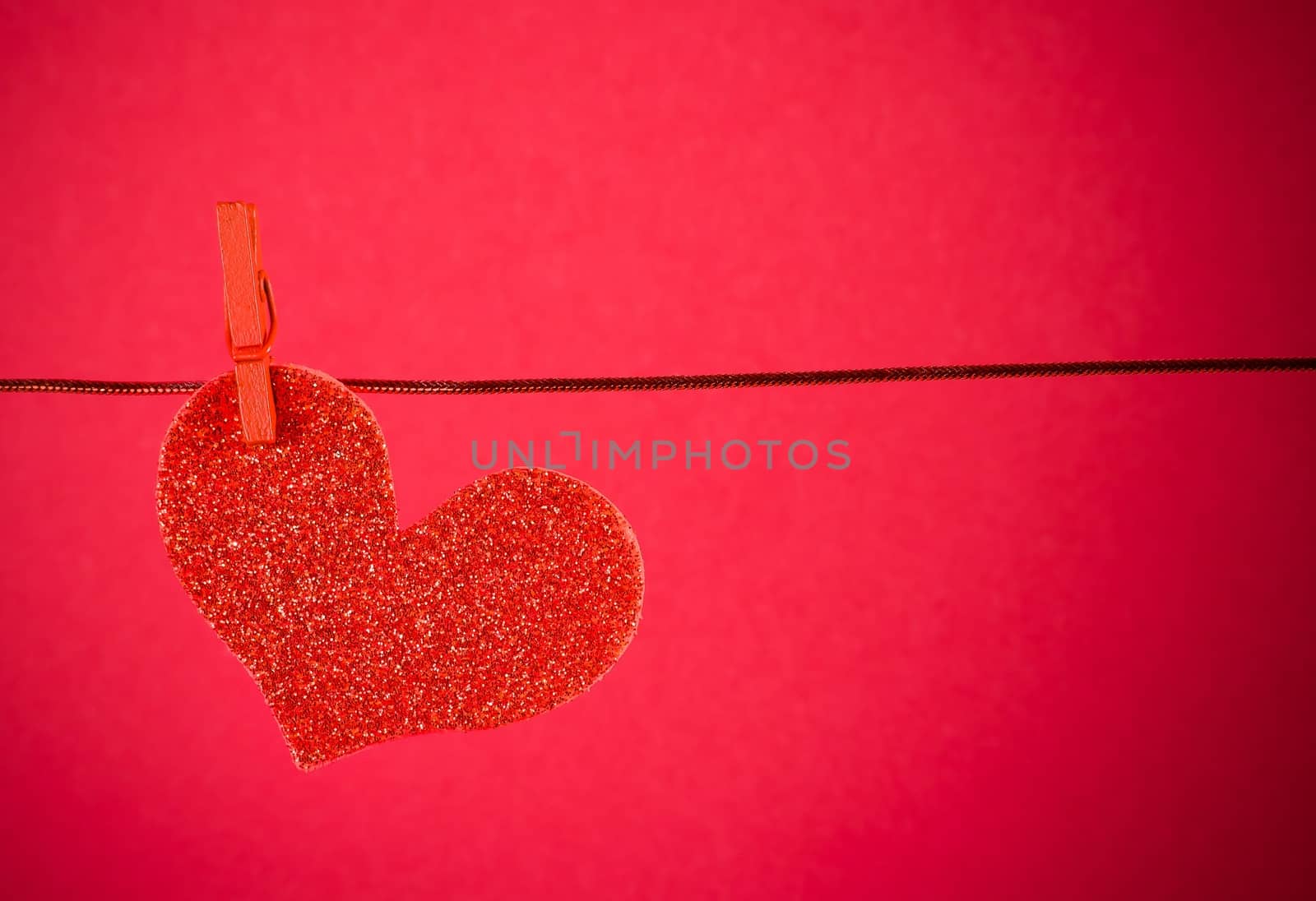 decorative red heart hanging on red background, concept of valentine day by donfiore