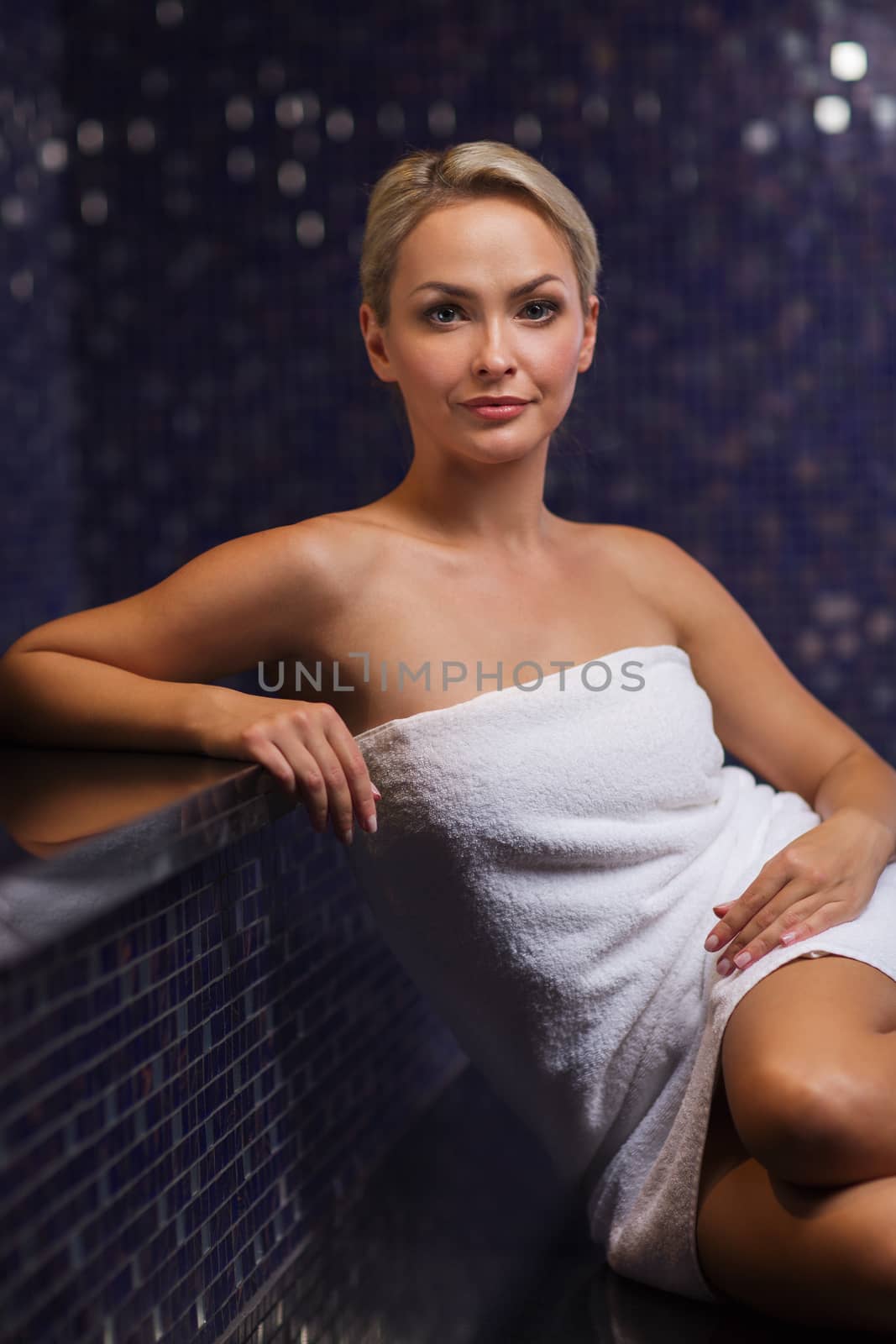 beautiful young woman sitting in bath towel by dolgachov