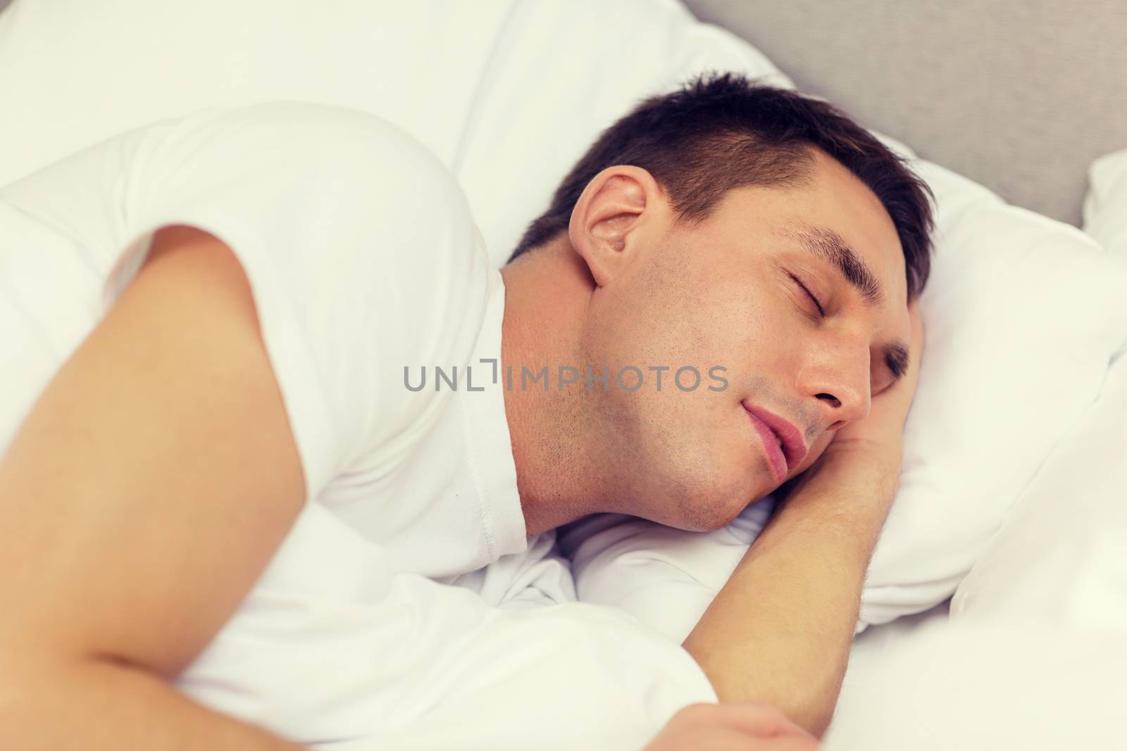 handsome man sleeping in bed by dolgachov