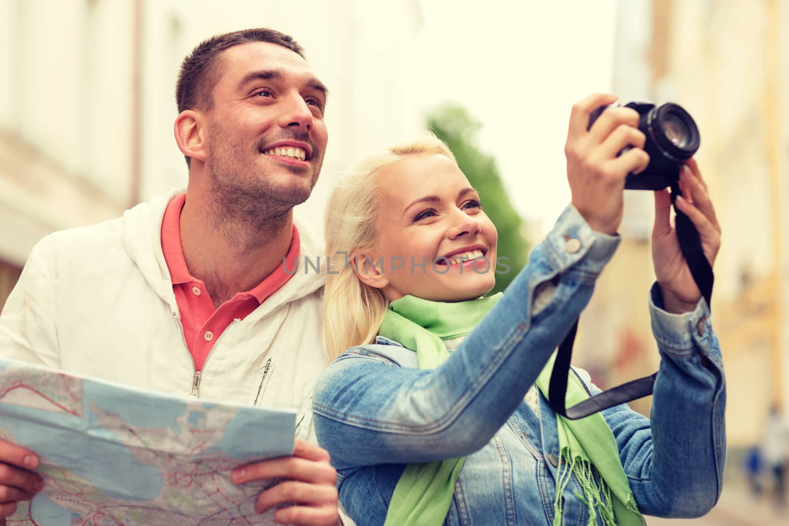 travel, vacation, technology and friendship concept - smiling couple with map and photocamera exploring city