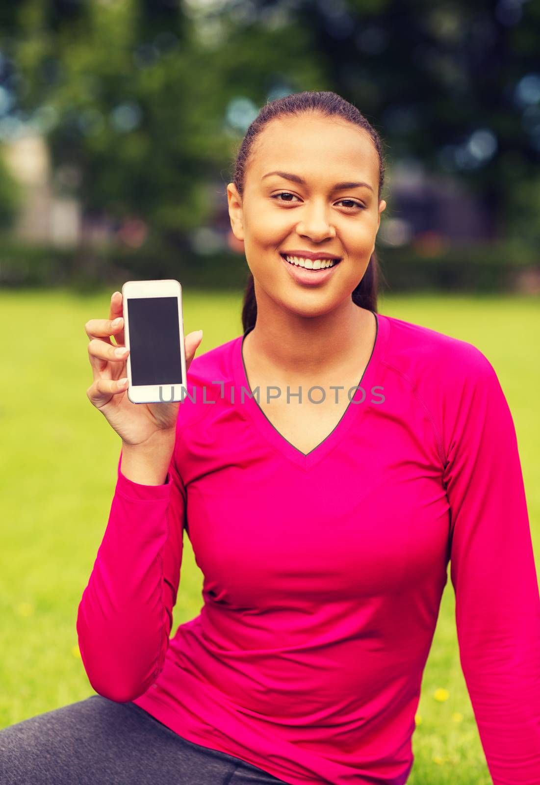smiling african american woman with smartphone by dolgachov