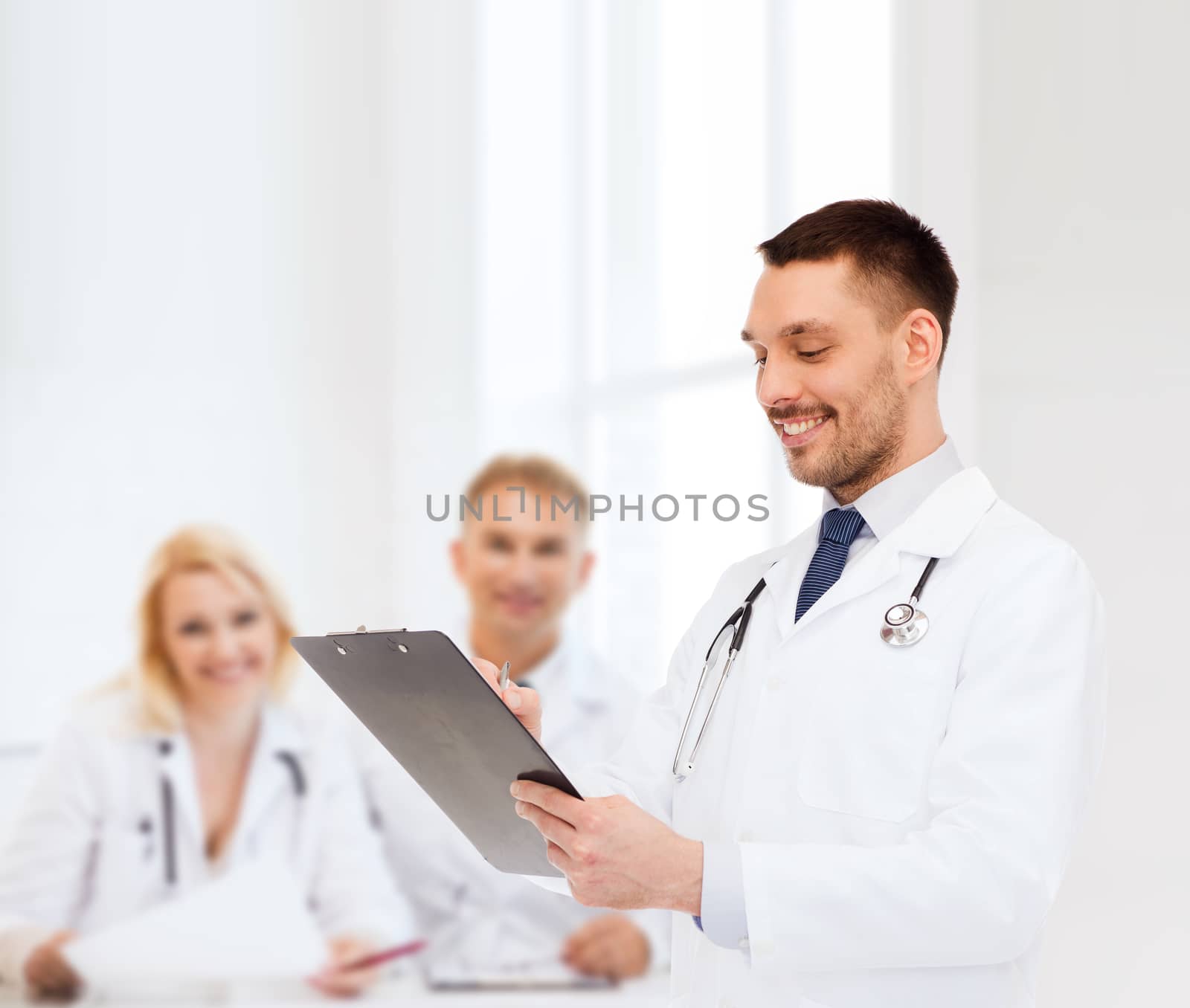 medicine, profession, and healthcare concept - smiling male doctor with clipboard and stethoscope writing prescription over white background