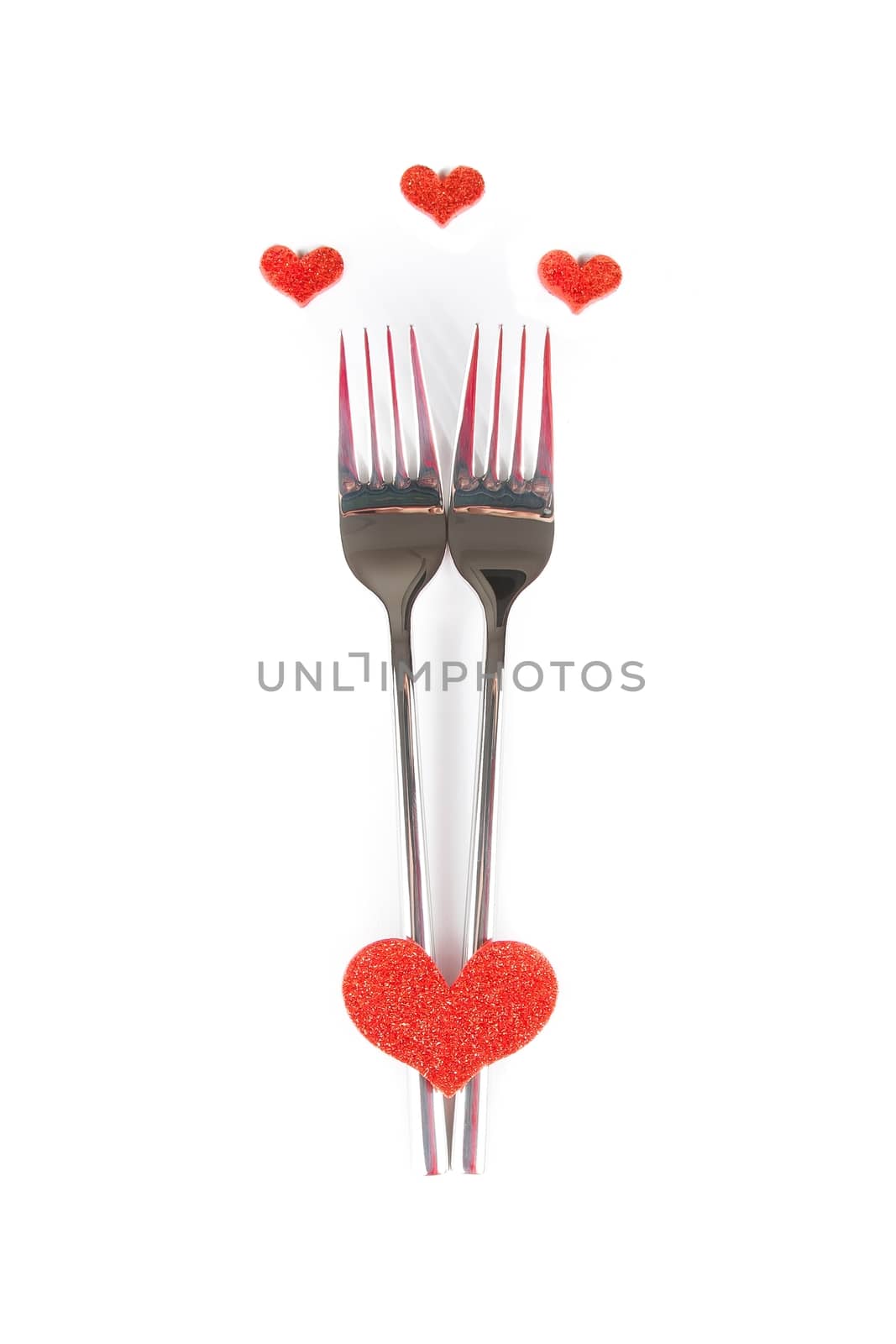 top of view of decorative red heart near forks on white background with space for text, concept valentine day dinner 