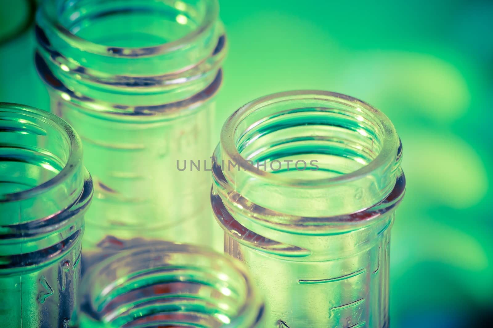 closeup of test tubes with red liquid in laboratory on green and yellow light tint background