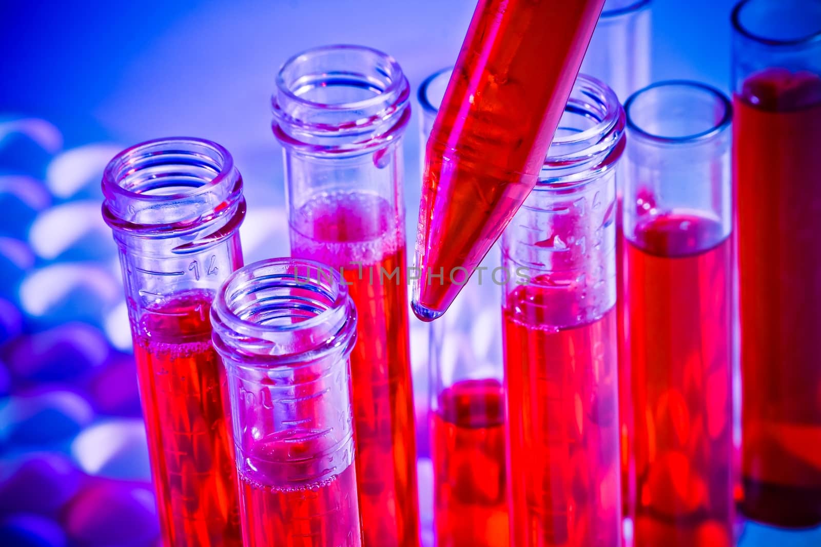 detail of test tubes with red liquid in laboratory on blue light tint background