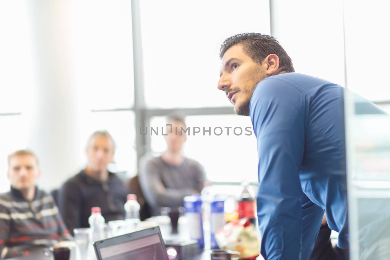 Business man making a presentation at office. Business executive delivering a presentation to his colleagues during meeting or in-house business training, explaining business plans to his employees.