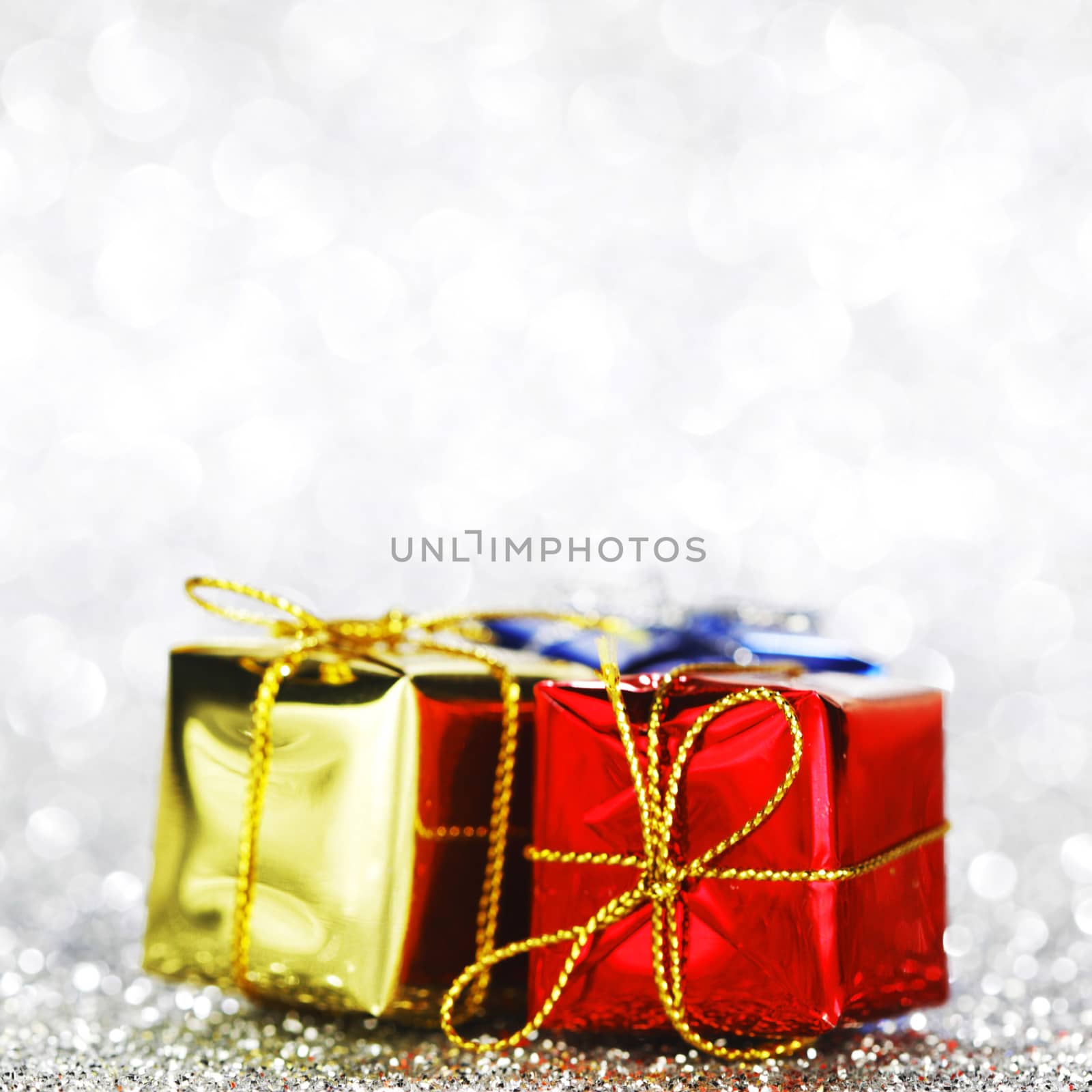 Decorated holiday gifts on silver background