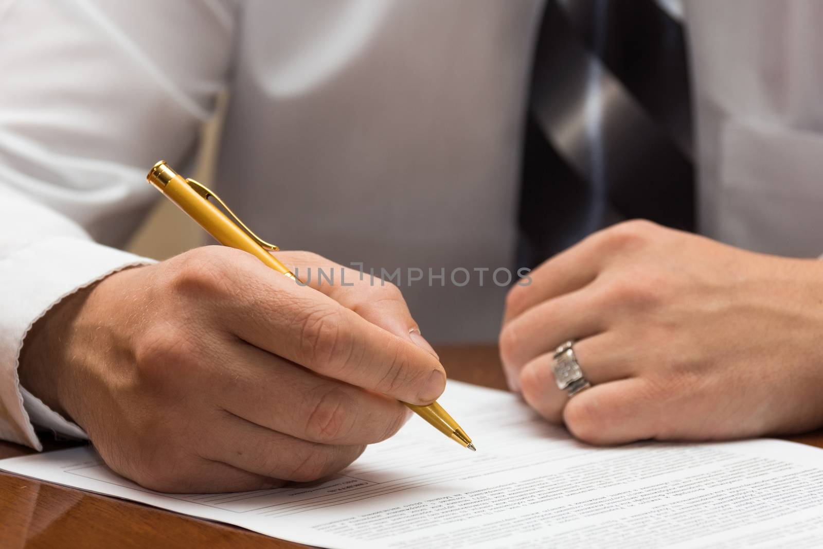 The photo depicts a man signs a document