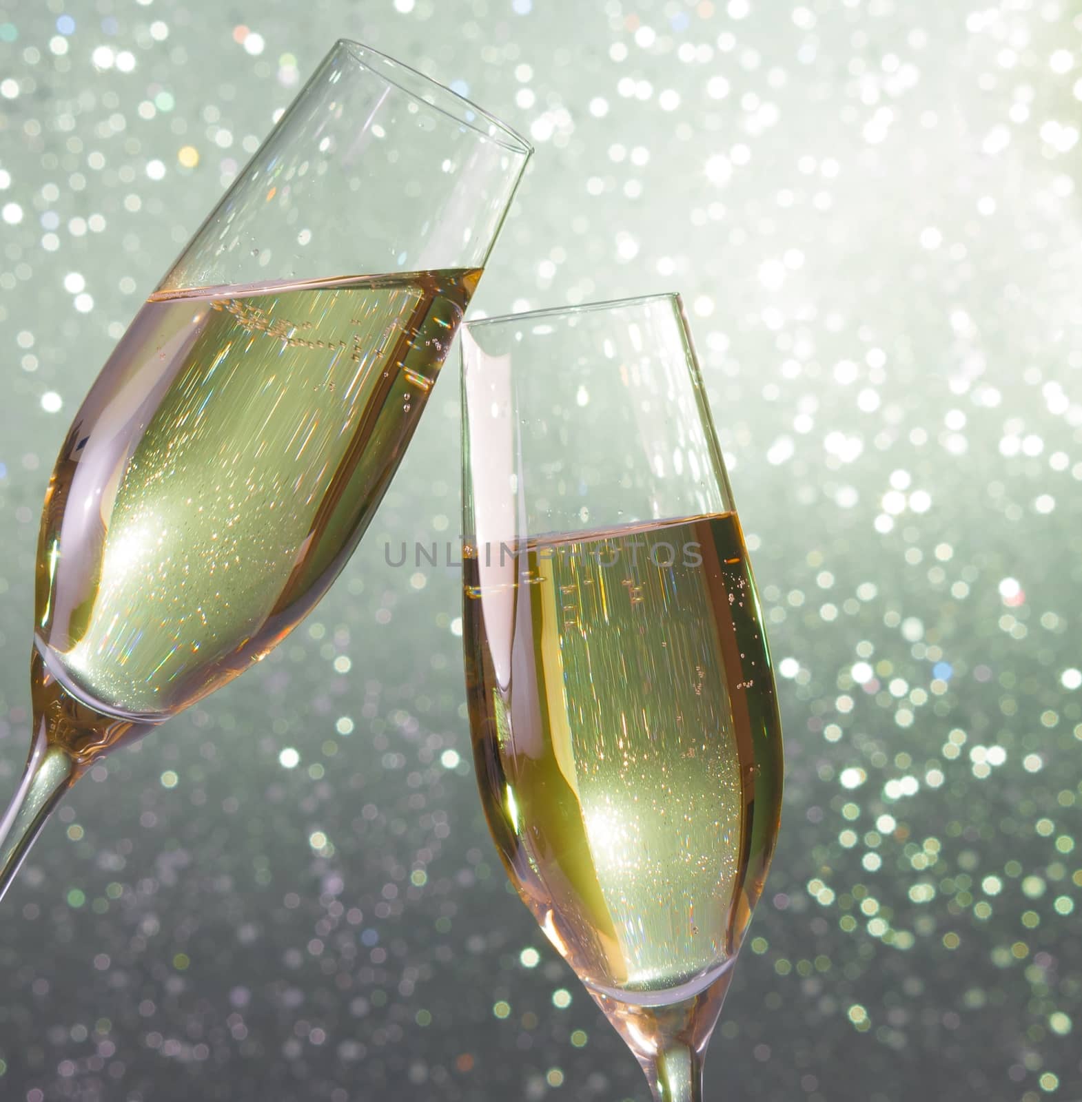 champagne flutes make cheers on silver light bokeh background
