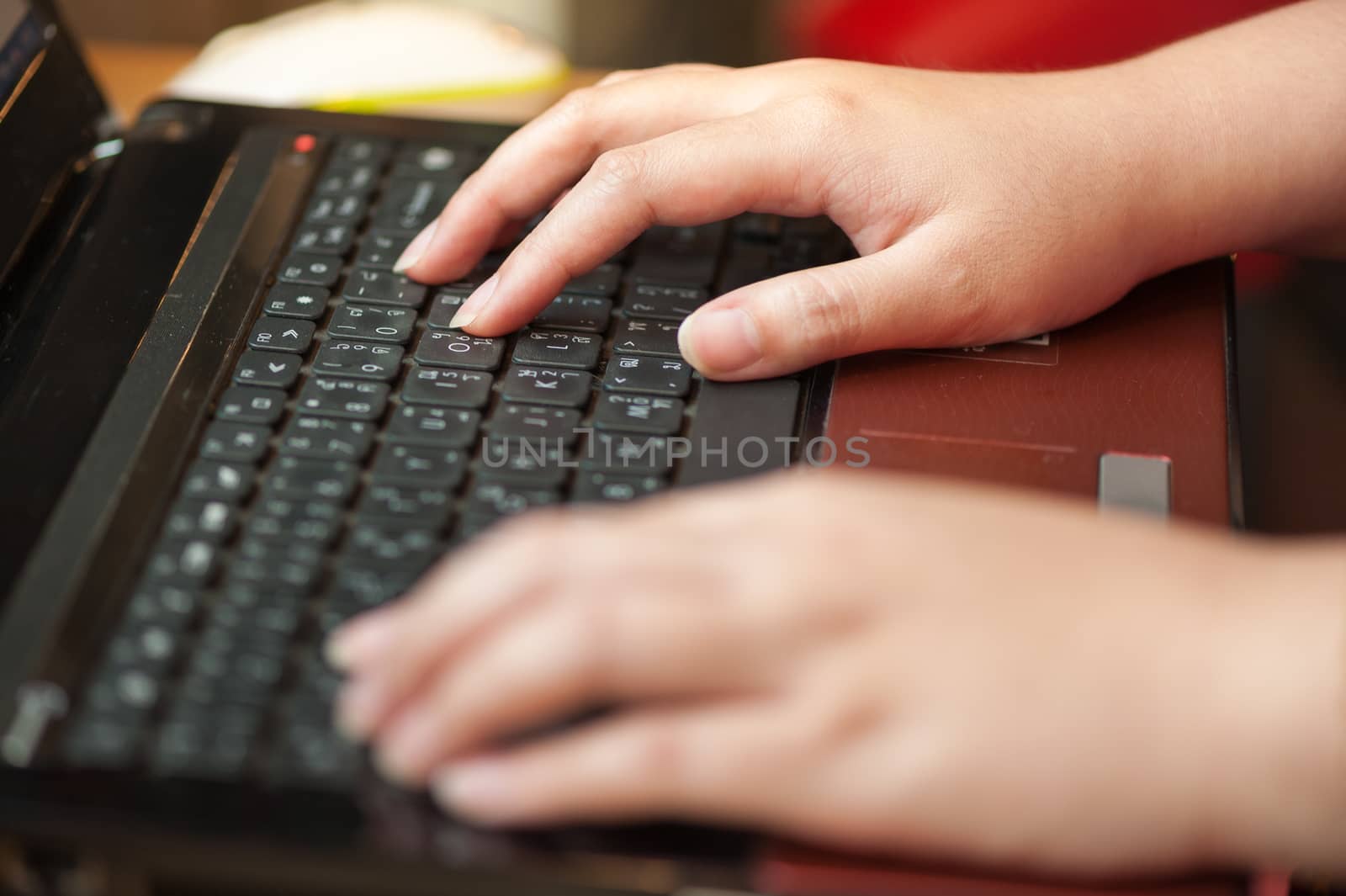 Female hand typing on laptop keyboard