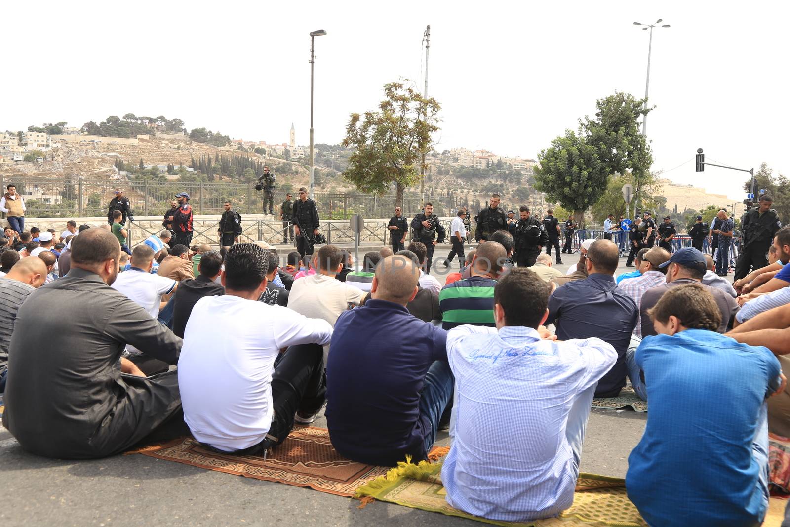 ISRAEL, Jerusalem: Security forces look on as people pray outside the Old City of Jerusalem, Israel on October 9, 2015.Worshipers were prevented from performing Friday prayers in Masjid Alaqsa after a string of lone-wolf stabbing attacks around throughout Israel over the last few weeks. Yesterday, 4 people were injured in a stabbing attack in Tel-Aviv before the attacker was shot and killed by police.