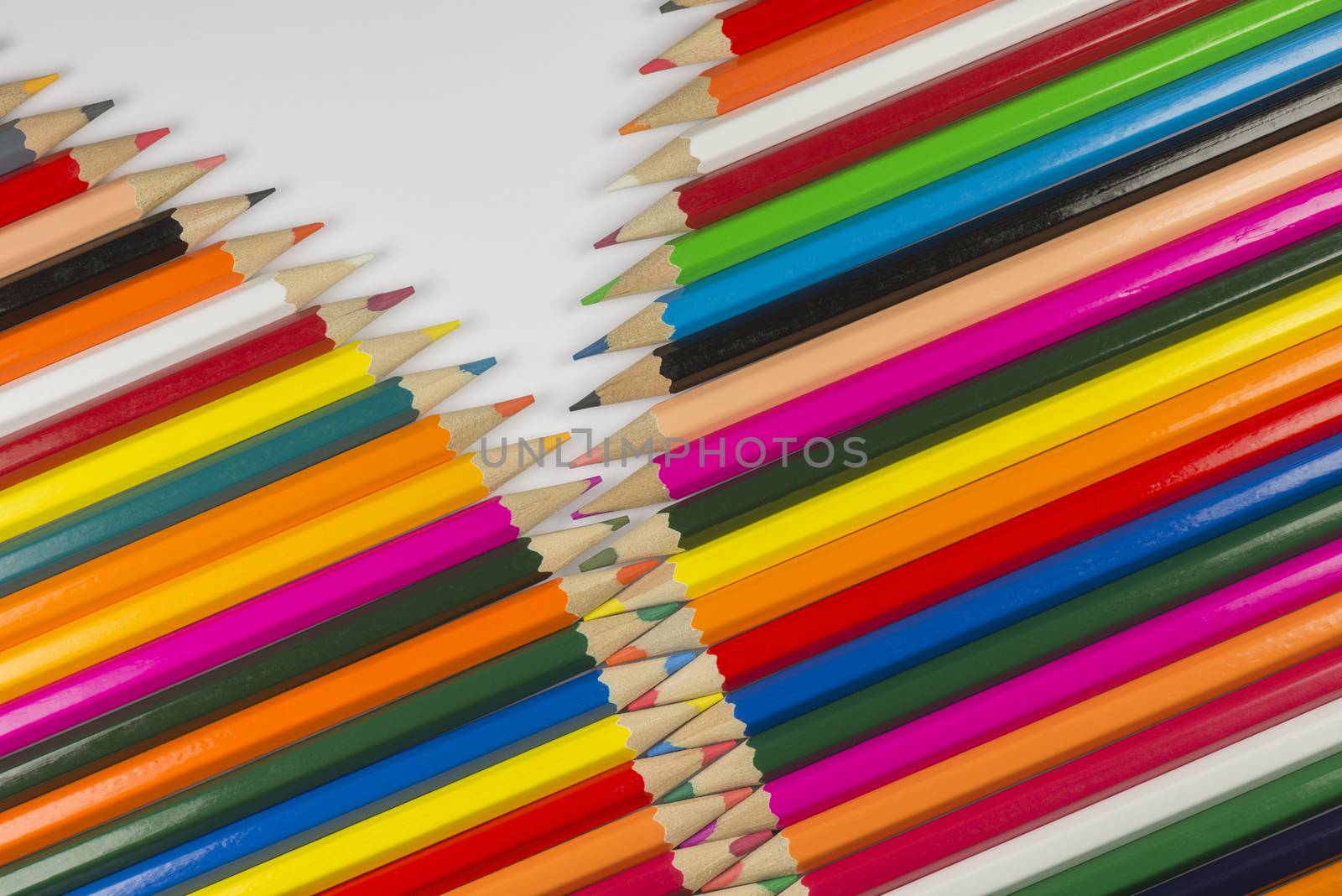 Abstract composition of a set cedar wooden colour pencils against a white background in zipper style
