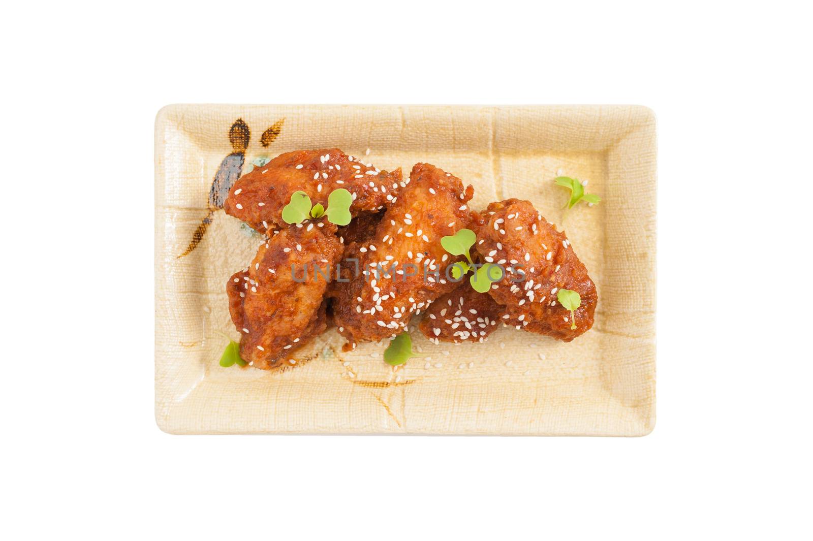Korean fusion style deep fried chicken wings seasoned with Korean spicy kimchi sauce on square ceramic dish
