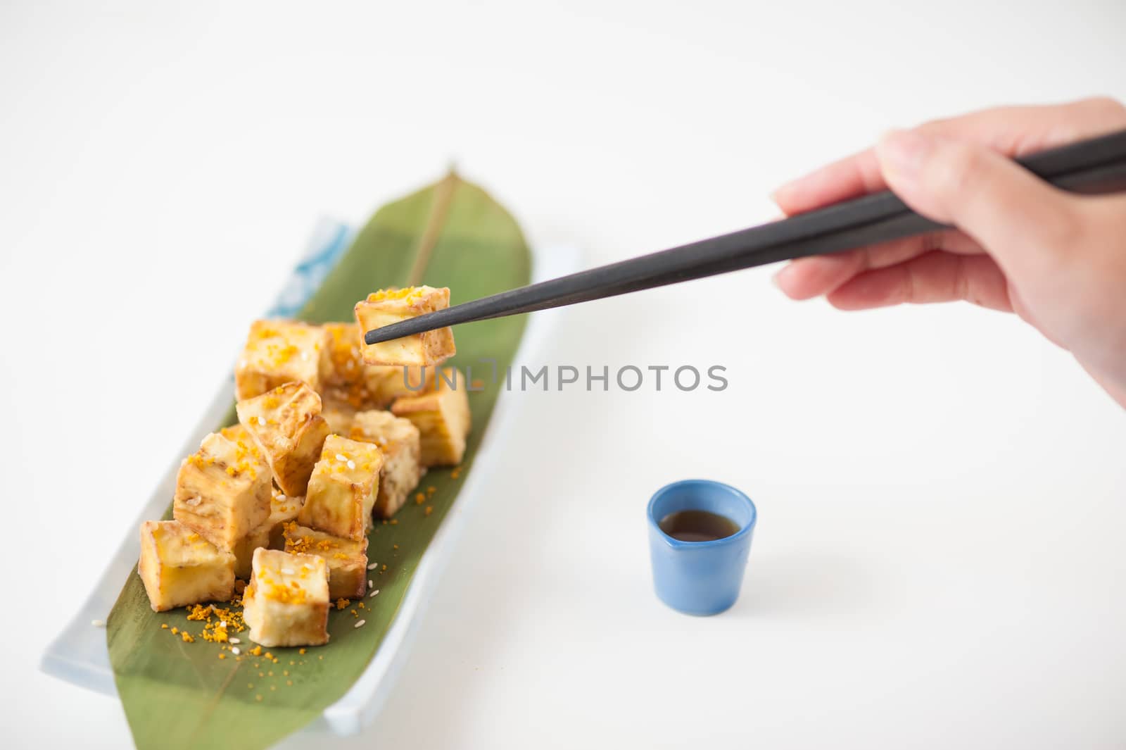 Fake fried tofu (using eggplant replace to tofu) on Japanese bamboo leaf with small cup of plum sauce