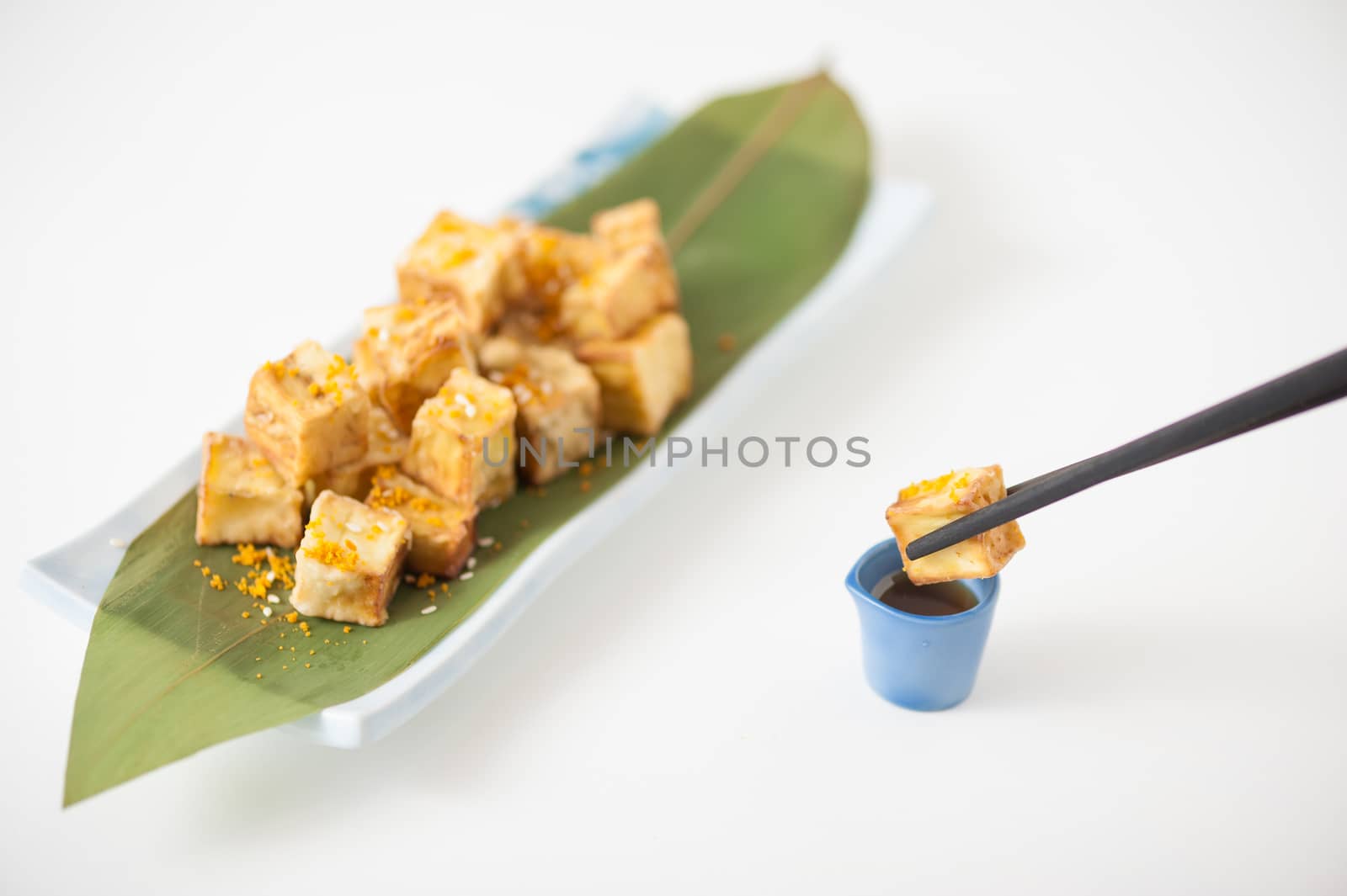Fake fried tofu (using eggplant replace to tofu) on Japanese bamboo leaf with small cup of plum sauce