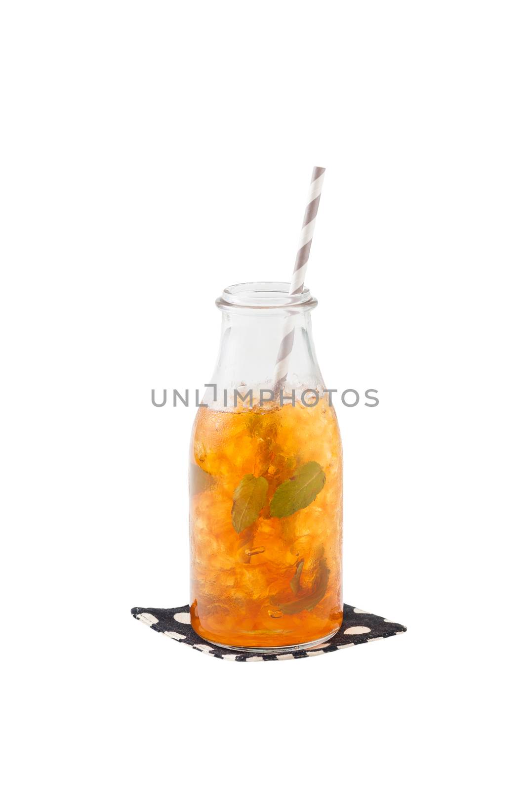 Iced peppermint toffee tea in glass bottle with striped straw garnished with mint leaves